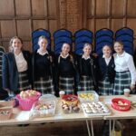 Girls next to the bake sale for children in need